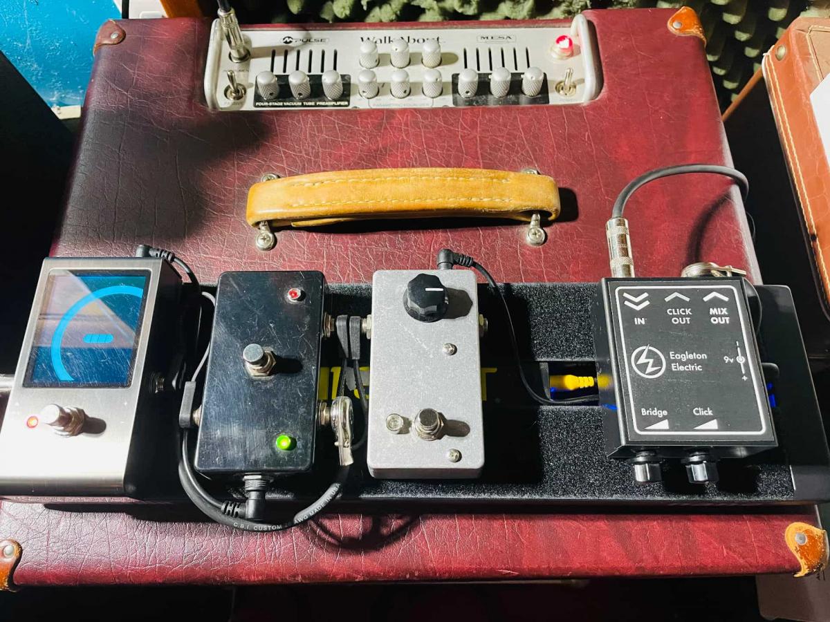 Pedalboard sitting on top of a bass amp